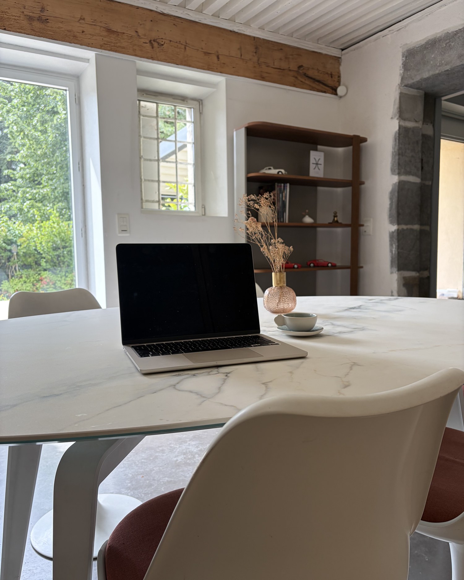 Espace de travail équipé : laptop, carnets, café