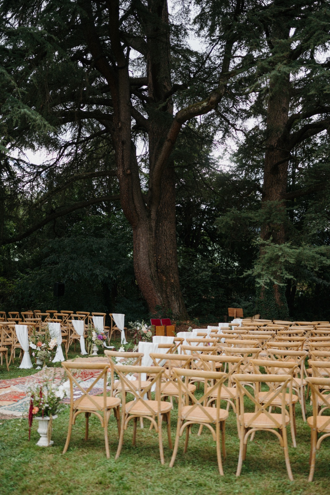 Cérémonie laïque installée sous les cèdres centenaires, chaises en bois et tapis au sol